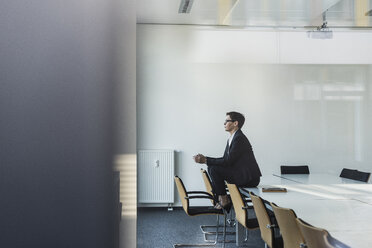 Geschäftsfrau sitzt am Konferenztisch - UUF10309