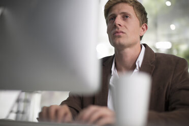 Junger Geschäftsmann bei der Arbeit im Büro - ZEF13246