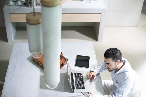 Junger Geschäftsmann, der im Büro arbeitet und mobile Geräte benutzt, lizenzfreies Stockfoto