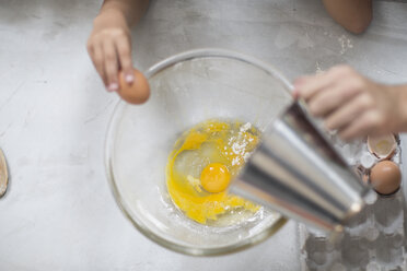 Boy cracking eggs into bowl - ZEF13309
