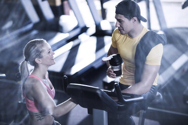 Junger Mann und Frau unterhalten sich im Fitnessstudio - ZEF13324