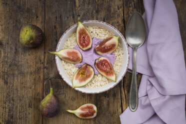 Bowl of overnight oats with blueberry yoghurt and figs on wood - LVF05957