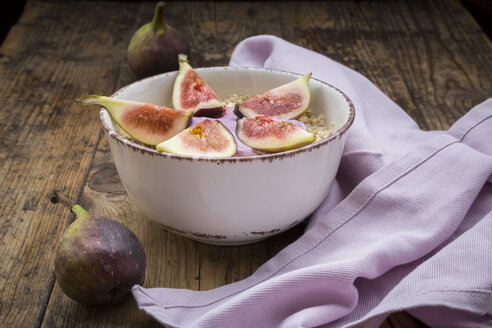 Bowl of overnight oats with blueberry yoghurt and figs on wood - LVF05958