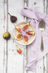 Bowl of overnight oats with blueberry yoghurt and figs on wood - LVF05959