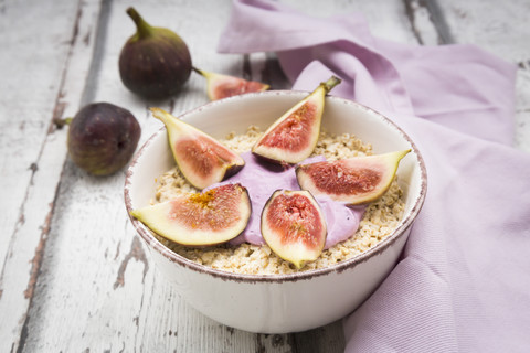 Schüssel Overnight Oats mit Heidelbeerjoghurt und Feigen auf Holz, lizenzfreies Stockfoto