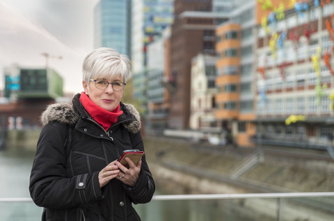 Germany, Duesseldorf, portrait of senior woman with cell phone stock photo