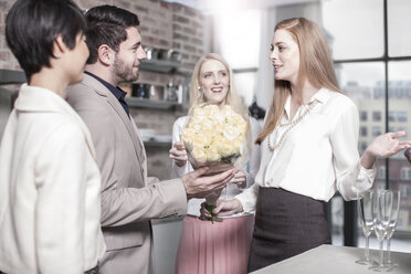 Mann übergibt Rosen an Frau in Küche - ZEF13347