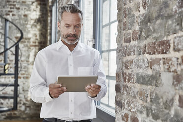 Businessman looking at tablet - FMKF03673