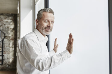 Portrait of confident businessman at the window - FMKF03675