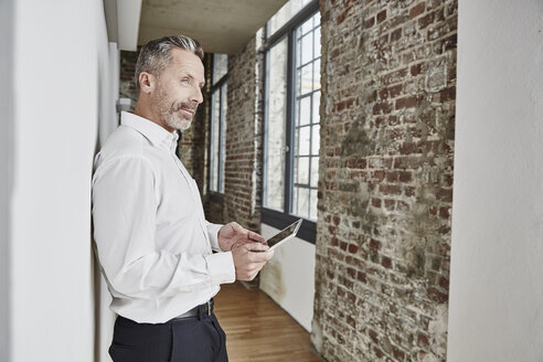 Geschäftsmann hält Tablet auf modernen Büro Etage - FMKF03681