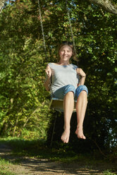 Smiling young woman on swing - JEDF00283