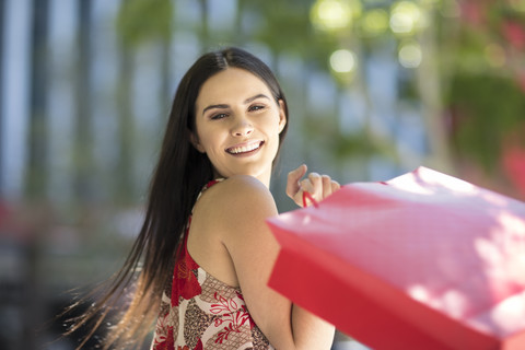 Portrait of happy young woman with shopping bags stock photo