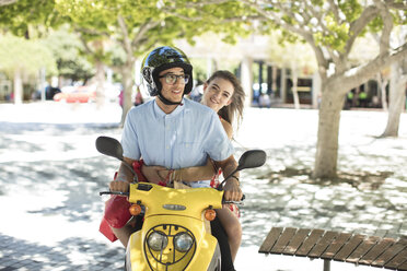 Glückliches junges Paar mit Einkaufstüten auf Motorroller - ZEF13410