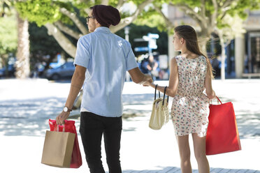 Junges Paar mit Einkaufstüten beim Spaziergang in der Stadt - ZEF13421