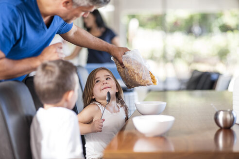 Father preparing cereal breakfast with kids - ZEF13424