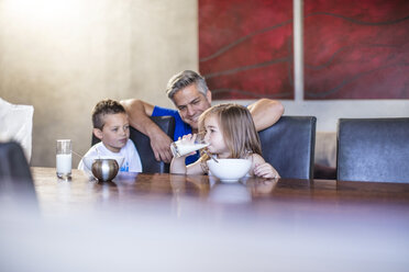 Glücklicher Vater mit Kindern beim Frühstück am Tisch sitzend - ZEF13432