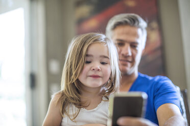 Father and daughter sharing cell phone - ZEF13442