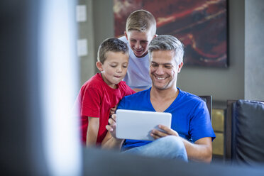 Children looking with their father on digital tablet - ZEF13445