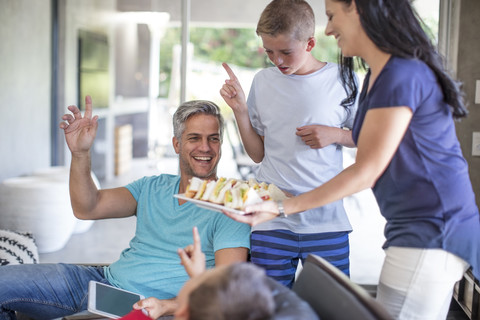 Mutter serviert Sandwiches für ihre Familie, lizenzfreies Stockfoto