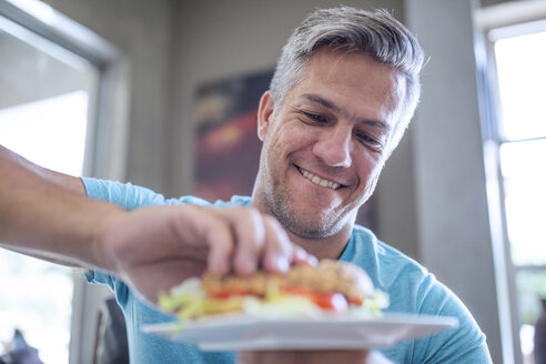 Man having a sandwich from plate - ZEF13455