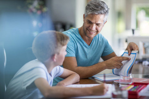 Vater hilft Sohn bei den Hausaufgaben, lizenzfreies Stockfoto