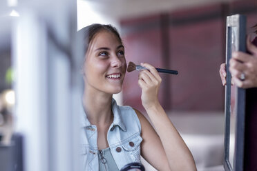 Girl applying make up while mother holding mirror - ZEF13484