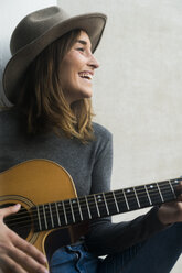 Happy young woman playing guitar - KKAF00637