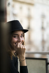 Portrait of smiling young woman wearing a hat - KKAF00639