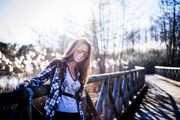 Frau auf Brücke stehend, lächelnd - SIPF01502