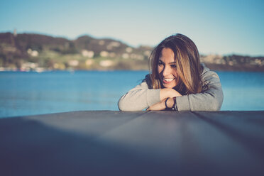 Porträt einer lächelnden Frau an einem See - SIPF01503