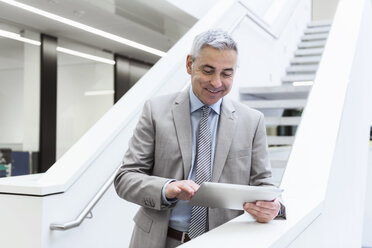 Porträt eines reifen Geschäftsmannes, der ein digitales Tablet benutzt - DIGF01568