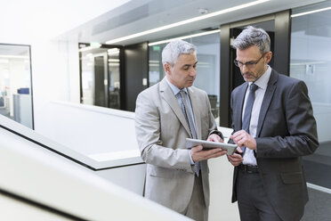 Two businessmen having an informal meeting, using digital tablet - DIGF01572