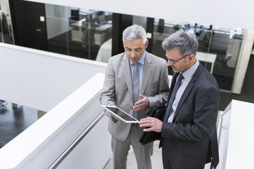 Zwei Geschäftsleute bei einem informellen Treffen, die ein digitales Tablet benutzen - DIGF01575