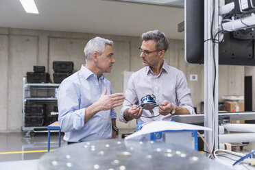 Two businessmen in factory hall examining product - DIGF01619