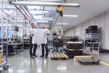 Two businessmen in factory hall discussing construction plan - DIGF01621