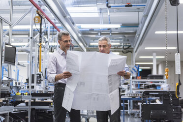 Two businessmen in factory hall discussing construction plan - DIGF01622