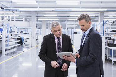 Two mangagers having a meeting at the shop floor of a factory - DIGF01634