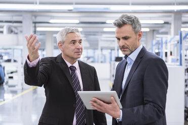 Two mangagers having a meeting at the shop floor of a factory - DIGF01635