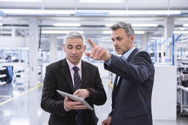 Two mangagers having a meeting at the shop floor of a factory - DIGF01636