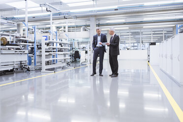 Two mangagers having a meeting at the shop floor of a factory - DIGF01644