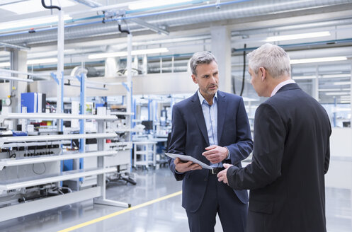 Zwei Manager bei einer Besprechung in der Werkstatt einer Fabrik - DIGF01647