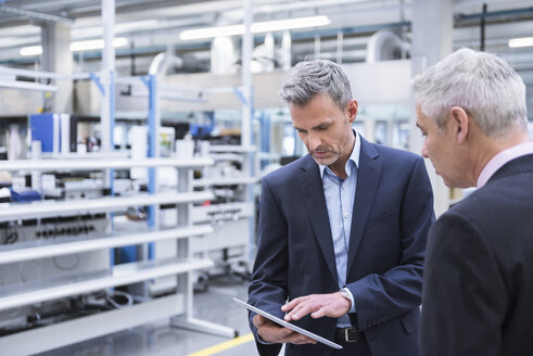 Zwei Manager bei einer Besprechung in der Werkstatt einer Fabrik - DIGF01648