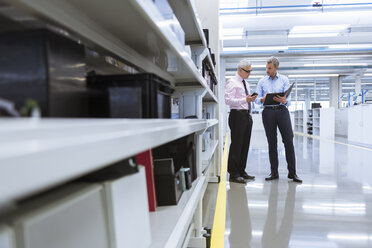 Zwei Manager diskutieren in der Fabrikhalle eines Unternehmens - DIGF01657