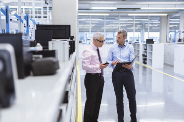 Two mangers discussing on shop floor of company - DIGF01658