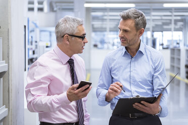 Two mangers discussing on shop floor of company - DIGF01659