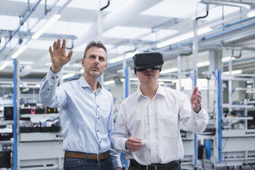 Two managers standing in company, using VR goggles - DIGF01699