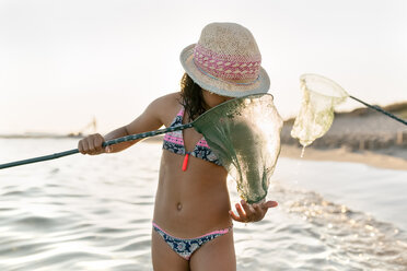 Spain, Menorca, girl with a dip net on the beach - MGOF03165