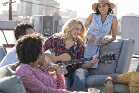 Friends having a rooftop party and playing guitar - WESTF22861