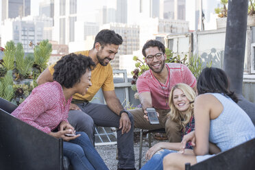 Freunde feiern eine Dachterrassenparty und benutzen einen Smart-Phone - WESTF22866