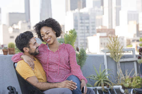 Paar auf der Dachterrasse sitzend, lizenzfreies Stockfoto